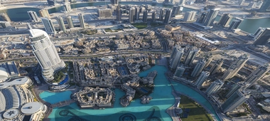Aerial view of the cityscape around Burj Khalifa, featuring architectural designs and a blue canal.