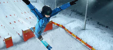 A skier in mid-air during a nighttime event, showcasing agility and the vibrant atmosphere of the competition.