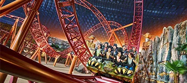A thrilling roller coaster ride set against a backdrop of rocky terrain and lush greenery, capturing the essence of amusement park excitement.