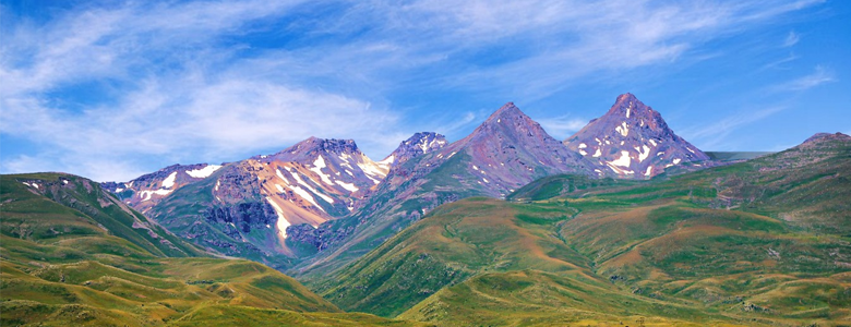 A traditional wooden boat carrying passengers on calm blue waters under a clear sky in Musandam 