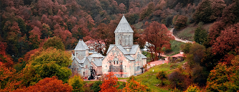 A traditional wooden boat carrying passengers on calm blue waters under a clear sky in Musandam 