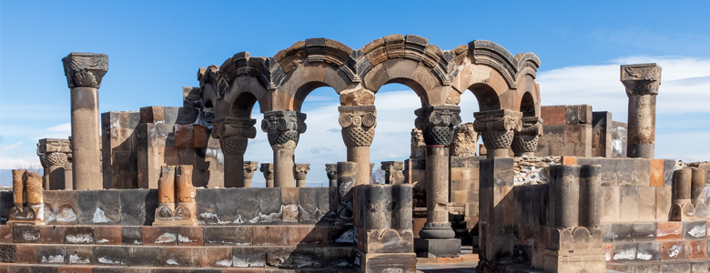 A traditional wooden boat carrying passengers on calm blue waters under a clear sky in Musandam 