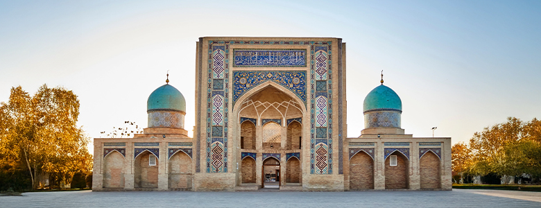A traditional wooden boat carrying passengers on calm blue waters under a clear sky in Musandam 