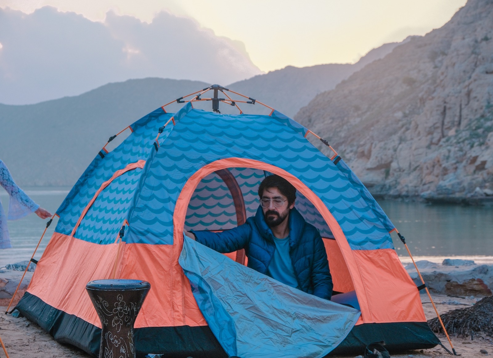 A traditional wooden boat carrying passengers on calm blue waters under a clear sky in Musandam 